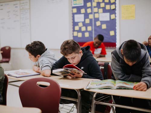 Young students reading at their desks.