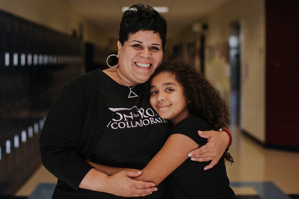 Youth leader and student in school hallway.