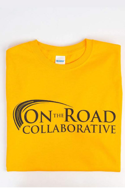 Yellow t-shirt with the "On the Road Collaborative" logo in black
